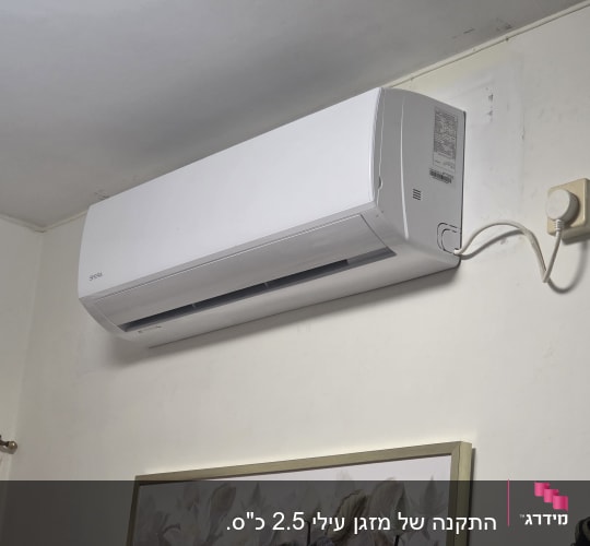 מזגן מותקן על קיר בחדר עם תמונה
